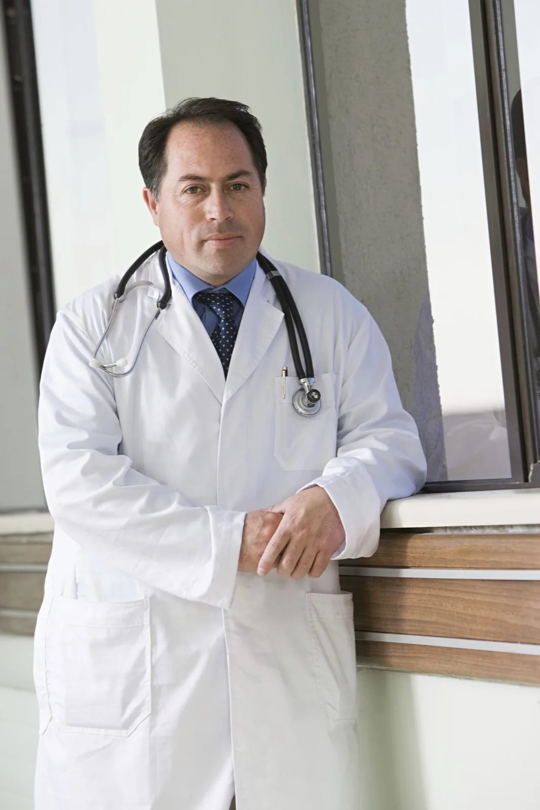 Médico de pie junto a una ventana